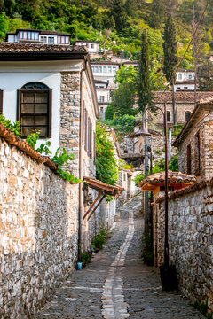 Vertical photograph of ancient paved street of the Gorica quarter of Old Town of Berat, in Albania on a sunny day. Ideal for travel brochure, magazine cover, poster.