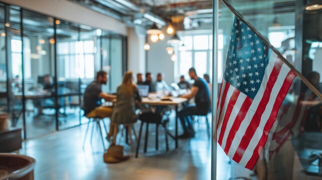 American flag in modern office with diverse team collaboration in background