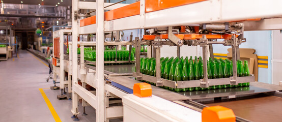 Glass factory, production of glass containers. Molten glass is blown into molds. Robotics in industry. Modern technologies, robotic machines produce products. Technological work at the plant.