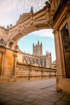 Vertical photograph of Bath Abbey with an arch and old street in Bath, England. Ideal for travel brochure, magazine cover, poster.