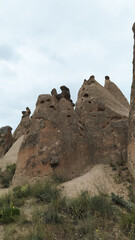 Bizarre ghost-shaped rock formations in the valley of Cappadocia against the cloudy sky, showcasing the natural beauty and geological wonders. Travel concept for Turkey tourist destinations.
