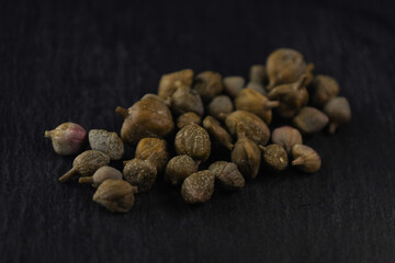 Vista ravvicinata di capperi su superficie nera.