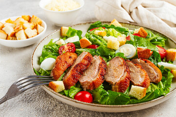 Caesar salad, with duck breast, on a light plate, on a light background, homemade, no people,