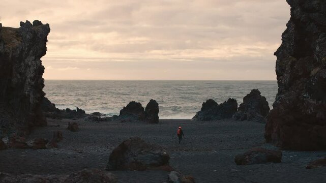 Man Exploring and Photographing Iceland&rsquo;s Black Sand Beach