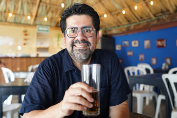Latino man enjoying a beer at a caribbean restaurant