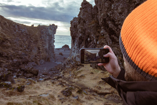 Man Exploring and Photographing Iceland&rsquo;s Black Sand Beach