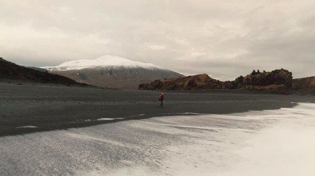 Man Exploring and Photographing Iceland&rsquo;s Black Sand Beach