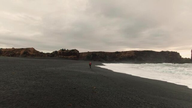 Man Exploring and Photographing Iceland&rsquo;s Black Sand Beach