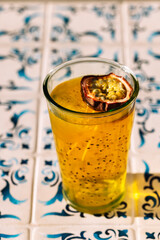 Close-up of a glass with a fresh healthy drink with passion fruit. Sweet juice with chia seeds. Delicious tropical cocktail.