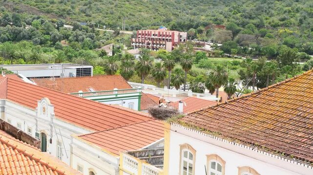 View over the rooftops in Silves, Portugal of a white stork siting in a large nest