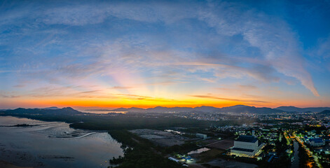 A stunning panoramic view of a coastal city at sunset at Phuket city, showcasing vibrant hues of...