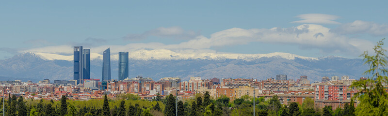 Obraz premium Panoramic view of Madrid, the capital of Spain, with the partially snow-covered mountains in the background.