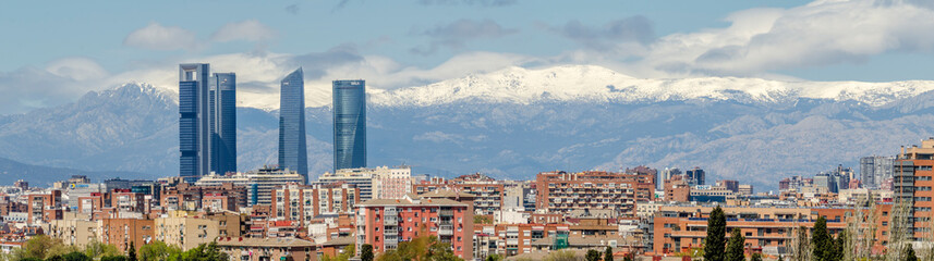 Fototapeta premium Panoramic view of Madrid, the capital of Spain, with the partially snow-covered mountains in the background.