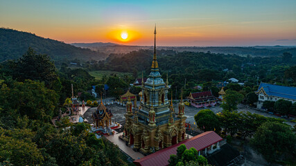 A breathtaking aerial view of a golden Buddhist temple at Wat Mae Klang Waterfall in Chiang Mai...