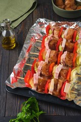 Step-by-step preparation of chicken, bell pepper, bacon and onion skewers on a dark background.