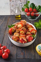 Step-by-step preparation of skewers on a skewer made of chicken, sweet pepper, bacon and onion on a light concrete background.