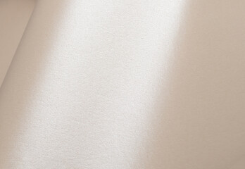 Creamy beige paper texture with a pearlescent finish, shimmering and sparkling surface, creating a...