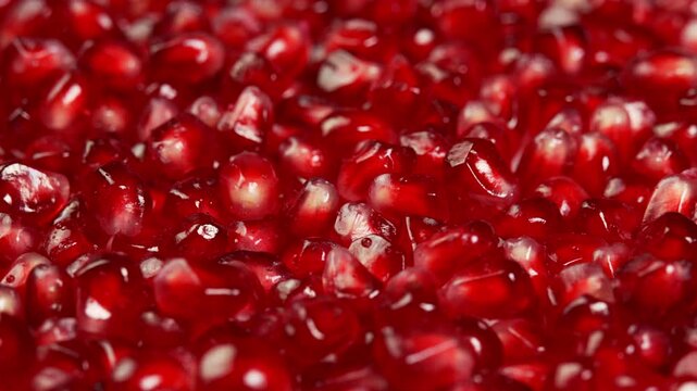 Juicy pomegranate seeds rotate as background showcase. Ruby pomegranate grains or garnet for satisfying, advertising and promotions. Juicy grenadine fruit natural antioxidant