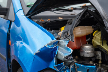Fototapeta premium heavily damaged car with crumpled hood and exposed engine, aftermath collision, crash scene, with visible damage to front end