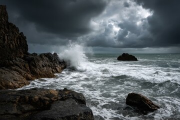 Obraz premium Powerful ocean waves crashing against rocky shore under a dramatic cloudy sky, creating sea spray and whitewater foam