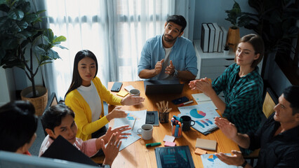 Top view of attractive diverse team clapping hands while project manager present creative idea at meeting room. Diverse team working together planning marketing strategy at meeting room. Convocation.