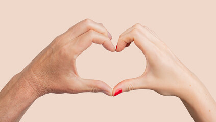 Fototapeta premium Hands forming a heart, symbolizing love, warmth, and togetherness. Affectionate gesture representing intimacy, partnership, and devotion between man and woman. A tender sign of connection, support,.