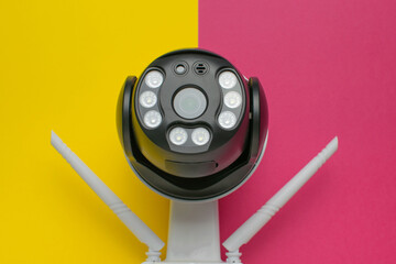 Modern Security Camera with Infrared LEDs on Vibrant Yellow and Pink Background