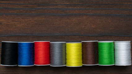 Colorful Sewing Thread Spools on Wooden Background for Craft and Fashion Projects