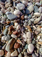 Colorful smooth pebbles on a beach forming a natural stone texture background with detailed close-up pattern