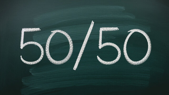Chalkboard with white chalk writing showing the fraction 50/50, representing balance, equality, or a 50-50 chance