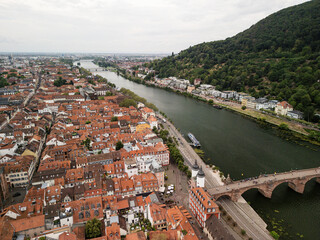 Scenic aerial view of a vibrant riverside town with terracotta rooftops and lush hills, showcasing urban architecture and natural beauty concept. Heidelberg