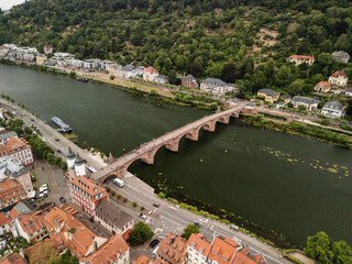 Obraz premium Scenic aerial view of a historic bridge spanning a river surrounded by lush greenery and charming architecture, travel destination concept. Heidelberg