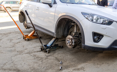 Car without wheels and lift up by jack stand .Waiting for tire replacement