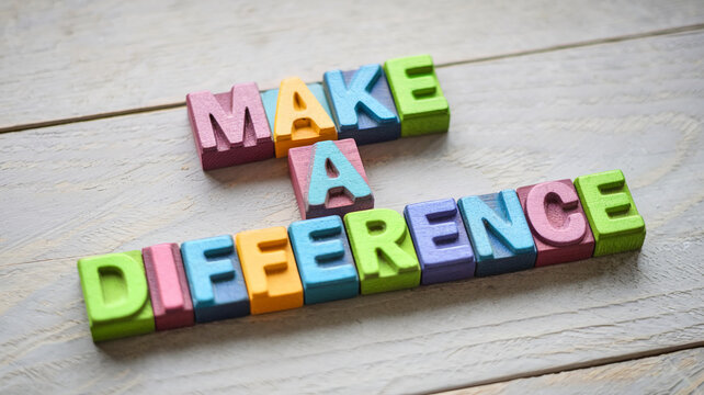 Colorful wooden letter blocks spelling "Make a Difference" on a light wood background, conveying a message of positive impact and social responsibility