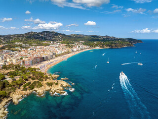 Fototapeta premium Resort town on the Mediterranean coast in Spain. Drone view of the main beach in the town Lloret de Mar, Girona Spain 