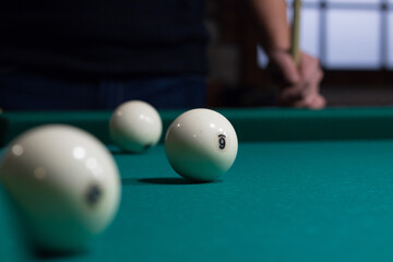 Russian billiards balls on green table cloth and player