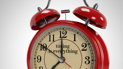 Red alarm clock closeup, featuring cream face and inscription "timing is everything", symbolizing time management and punctuality