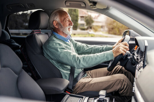 Side view of senior driver in smart causal driving his car.
