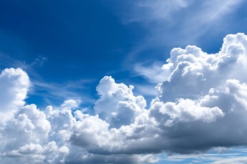 Obraz premium Blue Sky and Fluffy Cloudscape - Serene summer sky, puffy cumulus clouds, bright sunlight, airy atmosphere, peaceful nature. Symbolizing freedom, hope, tranquility, serenity, and renewal