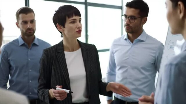 A diverse group of professionals engages in a productive discussion about business strategies. The meeting takes place in a bright office with modern decor, fostering collaboration and innovation