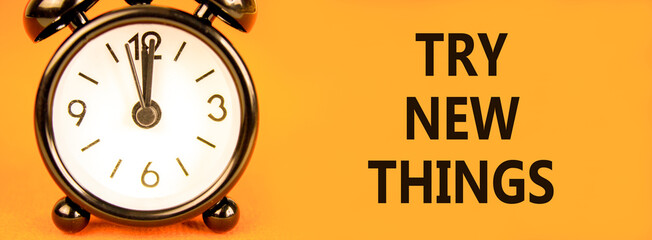 Try new things symbol. Concept words Try new things on beautiful orange paper. Alarm clock. Beautiful orange paper background. Business motivational lifestyle try new things concept. Copy space.