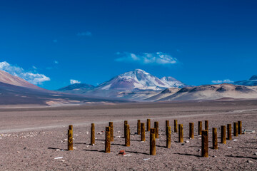 Ojos del Salado volcano mountain in Chile. Volcanic mountain landscape in arid dry altiplano high altitude plains, volcano high summit in Atacama desert arid soil and sand under blue sky with no cloud