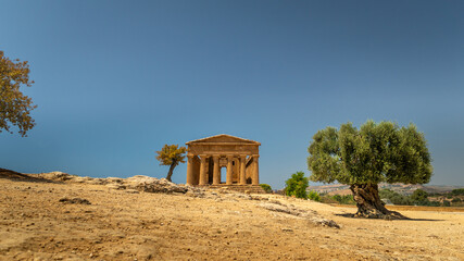 Valley of the Temples (Valle dei Templi) Temple of Concordia and the statue of Fallen Icarus, in the Valley of the Temples, Agrigento, Sicily, Italy. Travel and sightseeing journey concept