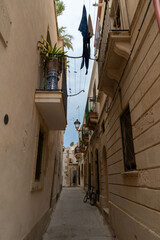 Narrow street in the old town of Syracuse in Sicily, Italy in a beautiful summer day. Travel and sightseeing journey concept.