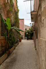 Narrow street in the old town of Syracuse in Sicily, Italy in a beautiful summer day. Travel and sightseeing journey concept.