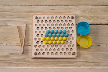 sorting board - games with colorful balls. The game is based on the Montessori system.