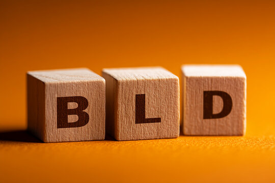 Three wooden cubes display letters BLD on orange background, showcasing concept of building or branding