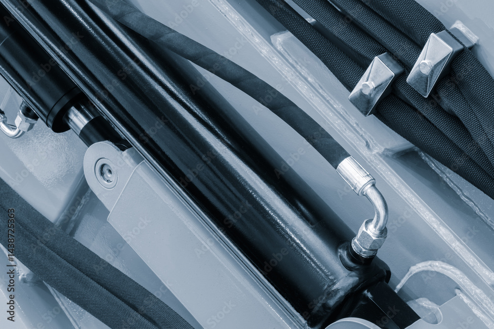 Poster a black hose with a silver connector is shown. the hose is attached to a machine and is black in col