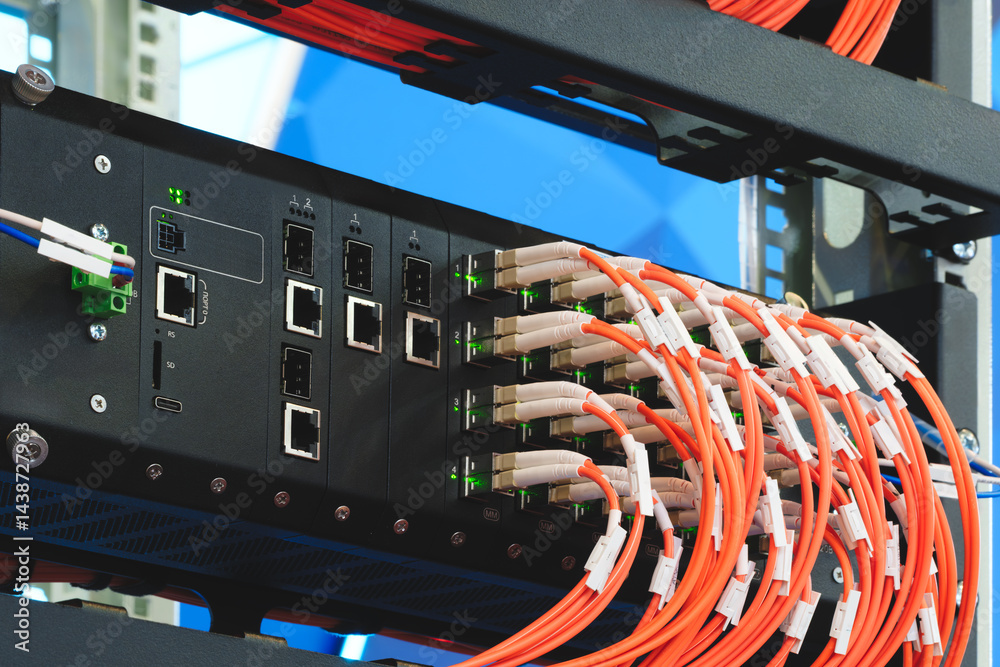 Poster a black box with lots of fiber optic wires coming out of it. wires are orange and white. box is on a