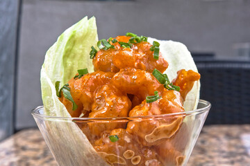 Breaded shrimp with spicy sauce and lettuce leaves, dynamite shrimp in a glass cup, seafood, food